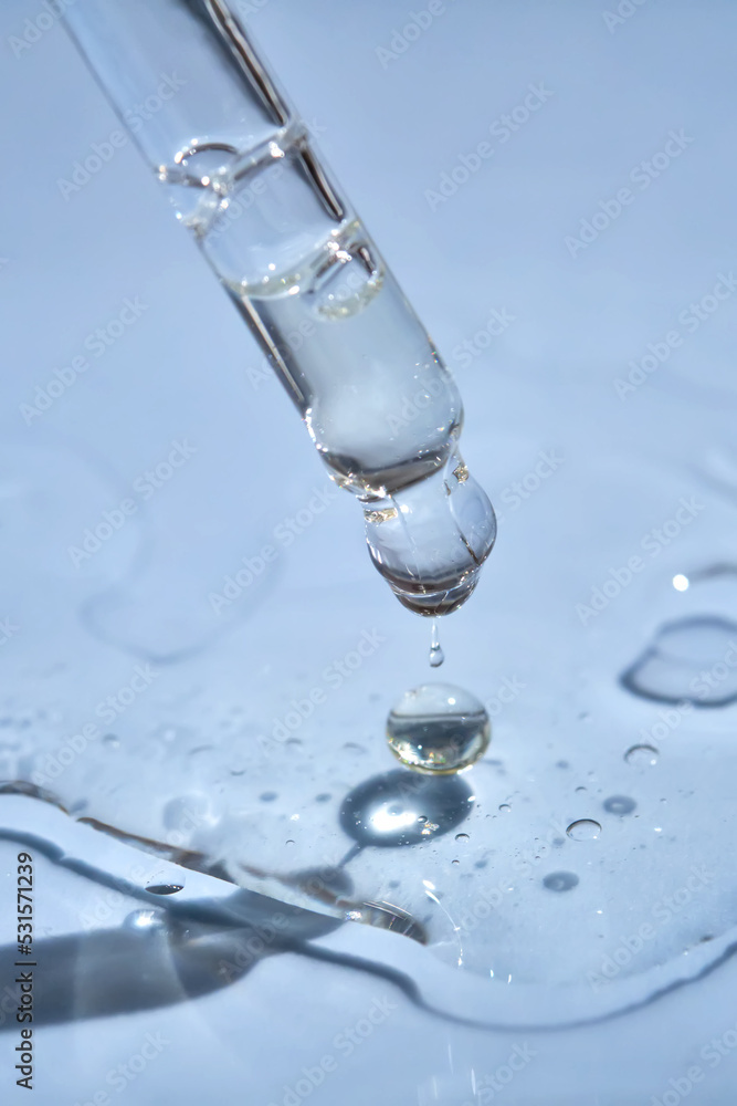 Dropper with serum or cosmetic oil on a blue background.
