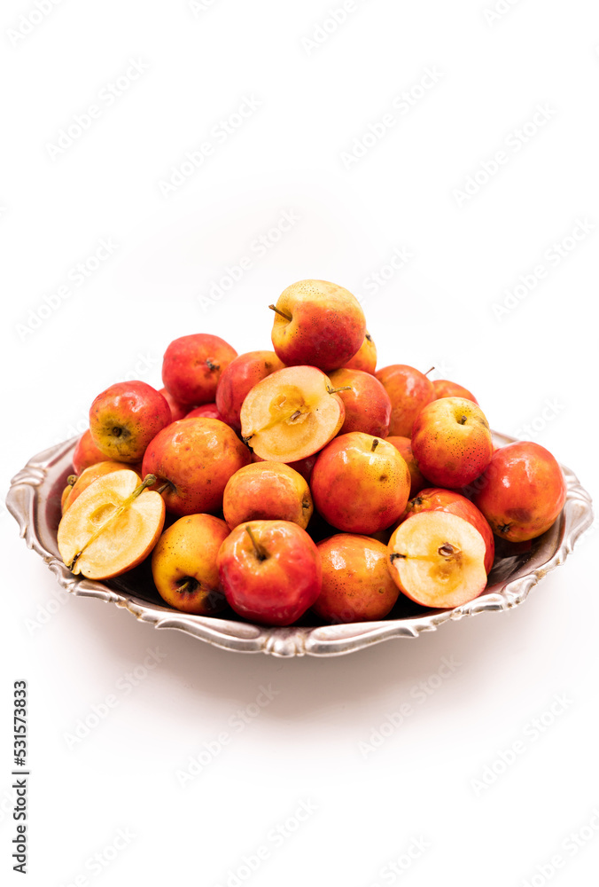 Ripe red small apples Ranetka on a metal plate, on a white background. Isolated background Ripe red small apples Ranetka on a metal plate, on a white background. Isolated background