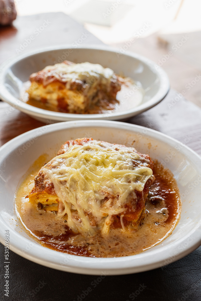 lasagna on white plate in restaurant lasagna on white plate in restaurant