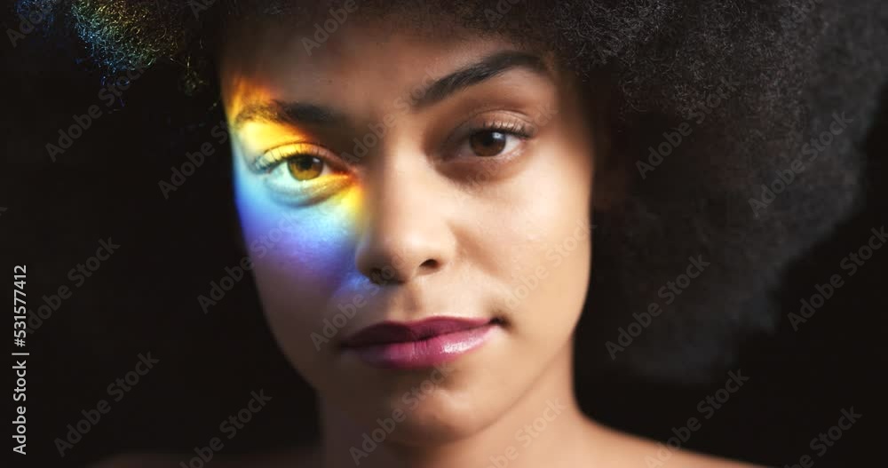 Rainbow, LGBT and spectrum light on black woman for beauty, glow or pride against a black background in studio. Holographic, flare and creative reflection with young female for art, fashion or prism Rainbow, LGBT and spectrum light on black woman for beauty, glow or pride against a black background in studio. Holographic, flare and creative reflection with young female for art, fashion or prism