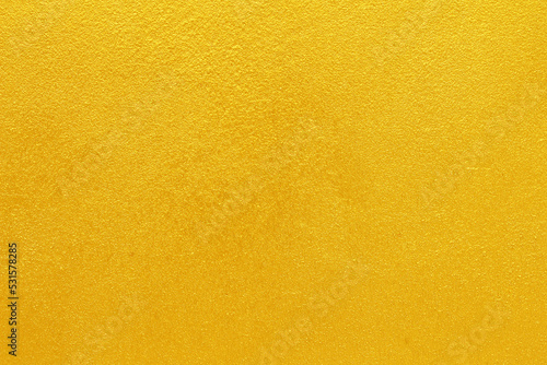 Gold or yellow paint on cement wall texture  background.