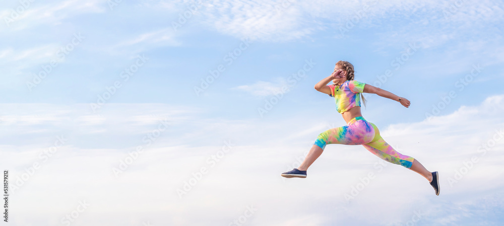 Girl athlete flies in jump against blue summer sky. There is no ground under your feet. Girl athlete flies in jump against blue summer sky. There is no ground under your feet.