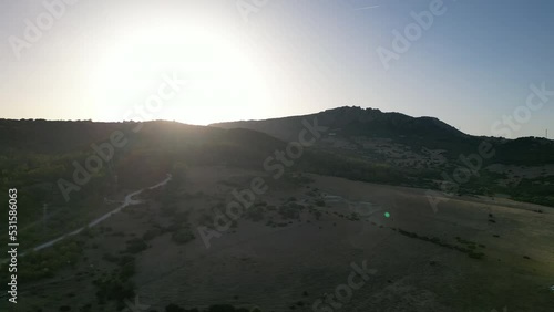 aerial shot tracking left to right revealing sunset setting behind mountains photo