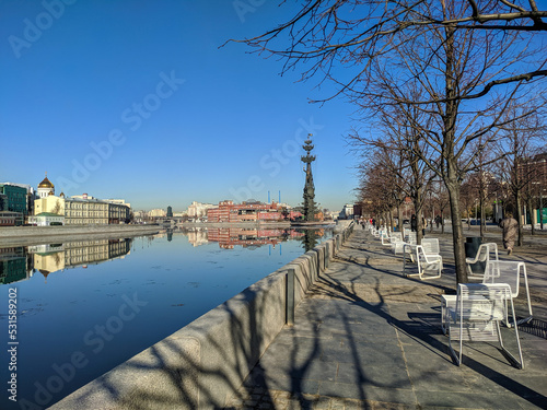 Moscow, Russia - March 01, 2022: Beautiful view of the embankment of the Muzeon Park against the blue sky. People walk along the Moscow River on a sunny spring day