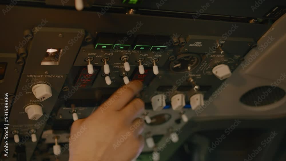 Airplane captain starting aircraft engine power buttons on control