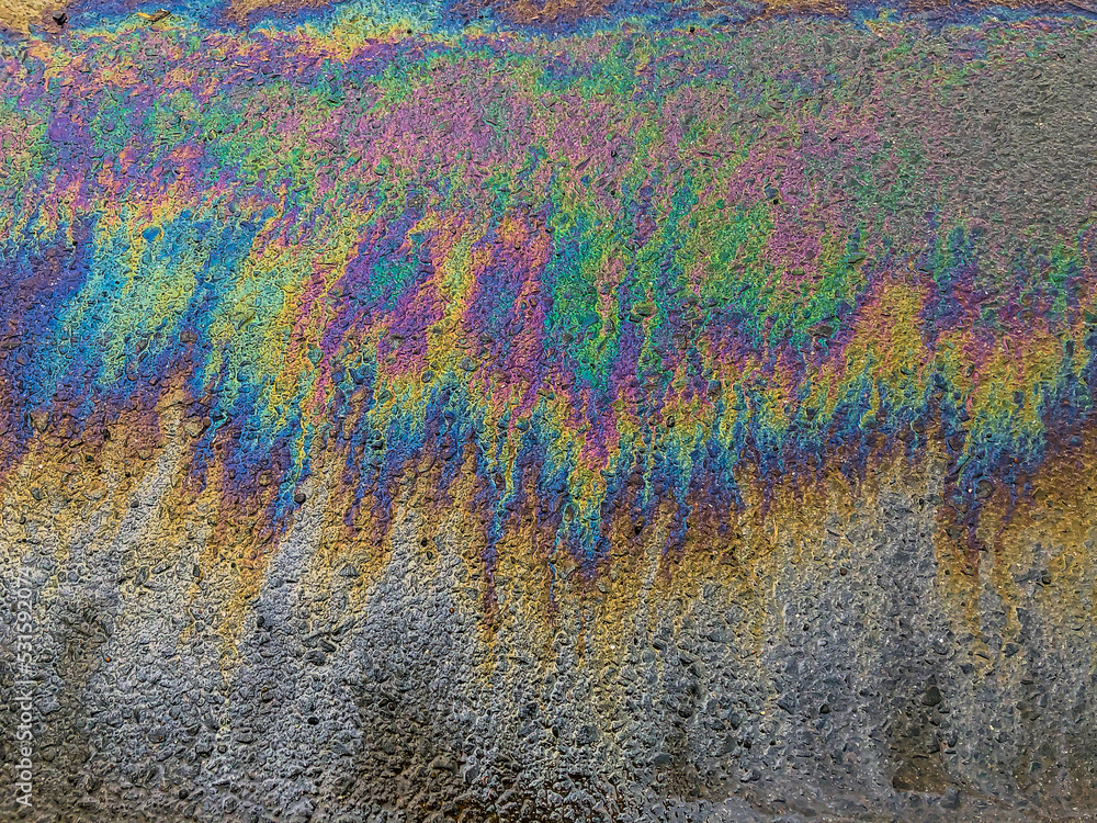 Oil stain on asphalt road, colour of gasoline fuel on asphalt road as background	