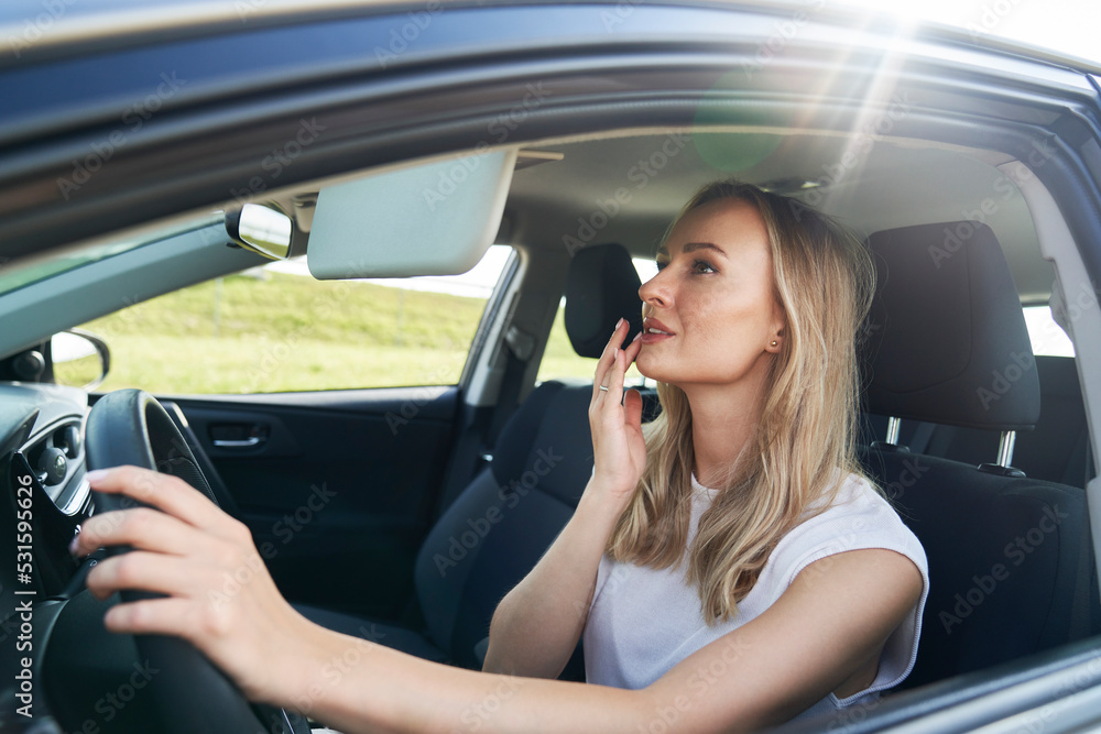 Caucasian woman preparing the makeup in the car Caucasian woman preparing the makeup in the car