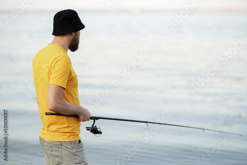 Fishing young man with sport fish rod for recreation on summer day. Recreational fishing fisherman outdoor leisure