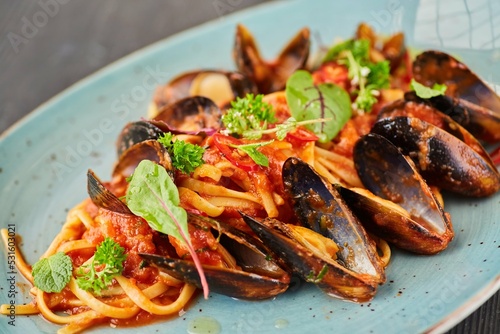 Pasta with mussels with red sauce. Food from the chef in a restaurant or cafe.