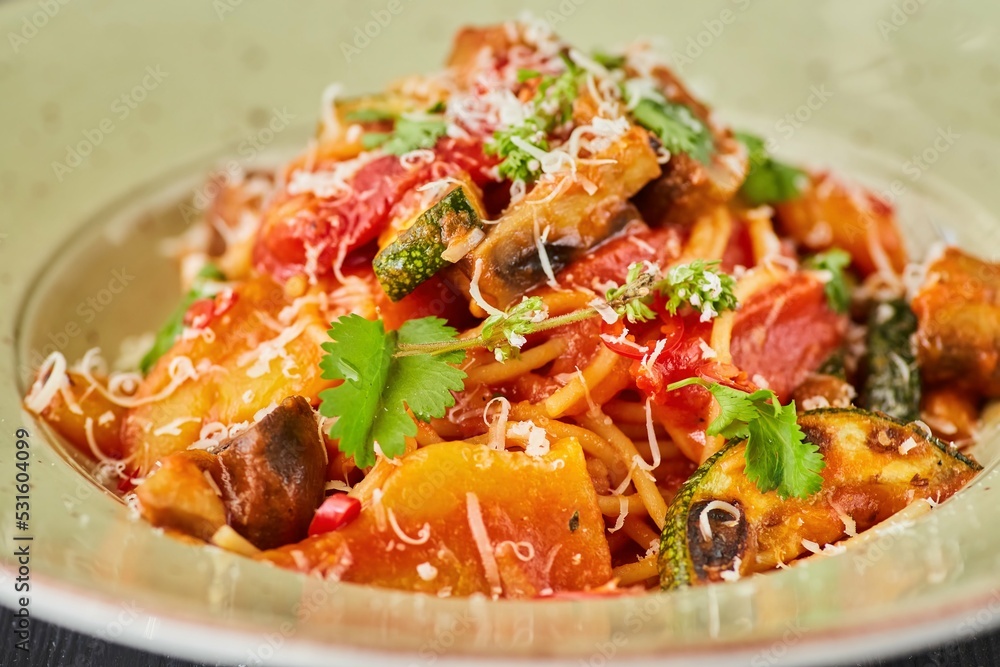 Pasta with chicken, zucchini and mushrooms with red sauce. Food from the chef in a restaurant or cafe. Pasta with chicken, zucchini and mushrooms with red sauce. Food from the chef in a restaurant or cafe.