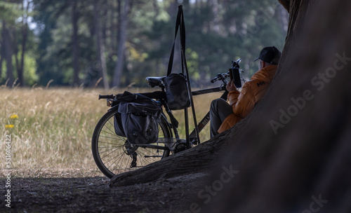 Photography An unrecognizable man sitting in the shade of a tree in Phoenix Park is holding