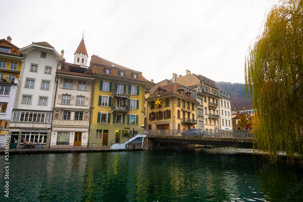 Beautiful view , medieval buildings , Aare lake and street in old town of Thun during autumn , winter cloudy day : Thun , Switzerland : December 2 , 2019