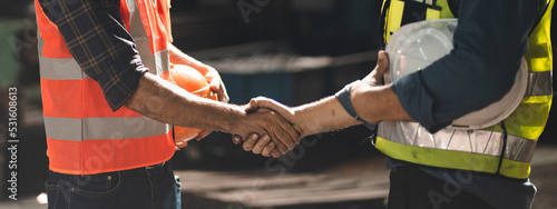 Fotografia Caucasian factory engineer talking and shaking hands on business cooperation agreement