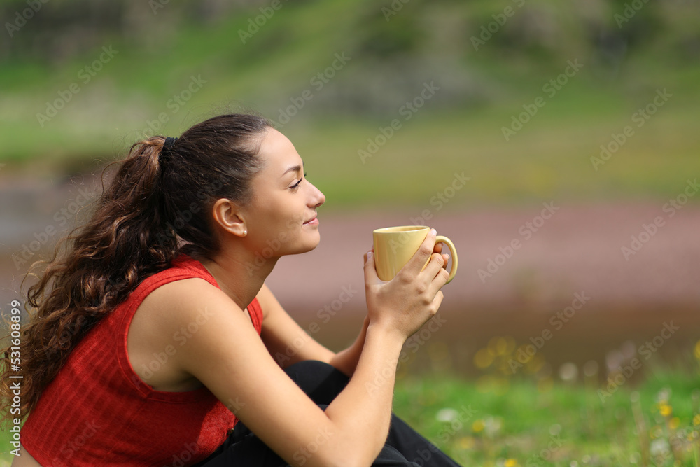 Woman drinking coffee in the mountain looking away Woman drinking coffee in the mountain looking away