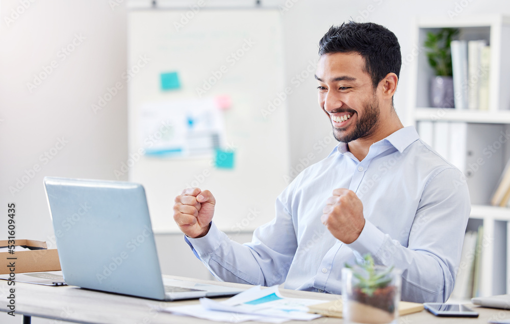 Motivation, success and yes with a business man in celebration and working on a laptop by his desk in the office. Email, good news and smile with a young and happy male employee cheering at work Motivation, success and yes with a business man in celebration and working on a laptop by his desk in the office. Email, good news and smile with a young and happy male employee cheering at work
