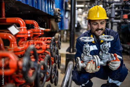 Industrial maintenance service and experienced engineer changing pipe valves in oil refinery plant. photo