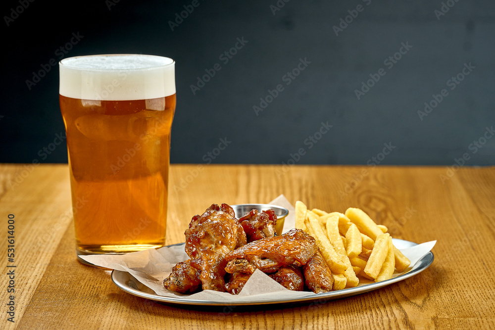 BBQ chicken wings. Beer snack. Close-up, selective focus. Noise added in post-production