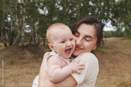 Mother carrying cute gir at park photo