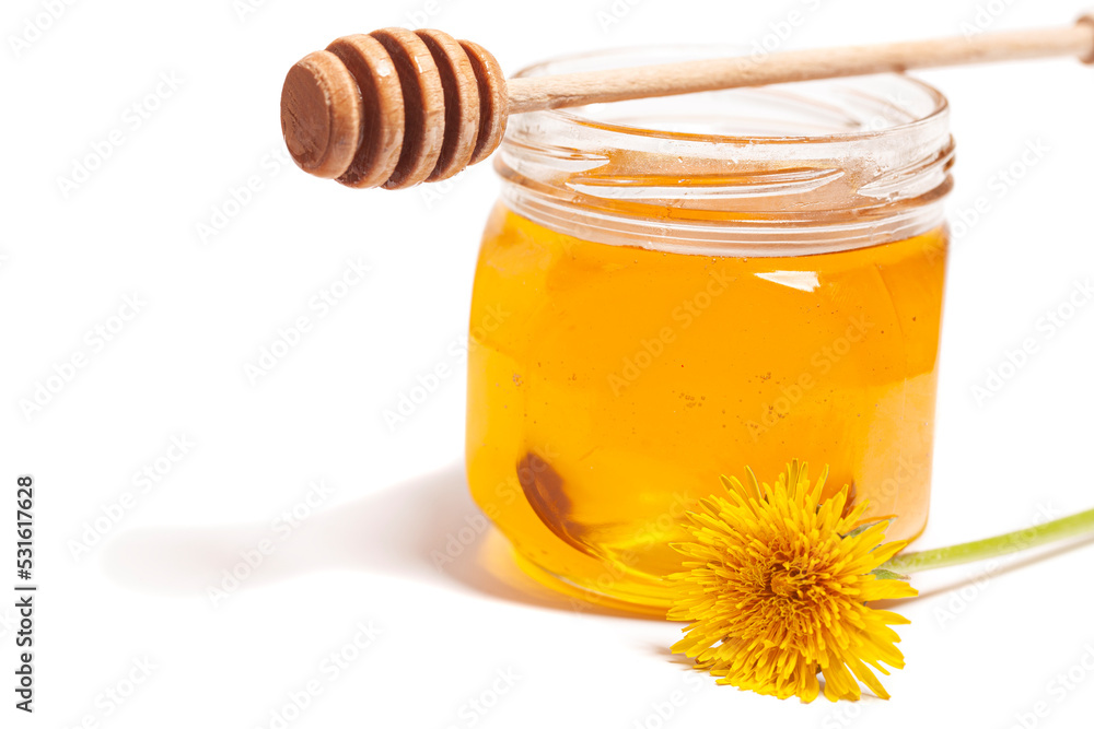 Honey dripping from honey dipper in glass jar with dandelion. Healthy food concept Honey dripping from honey dipper in glass jar with dandelion. Healthy food concept