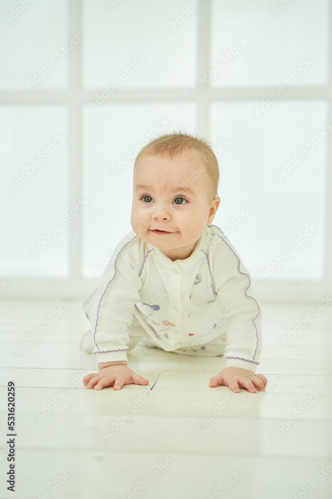 A small newborn baby is in a white room. The concept of childhood A small newborn baby is in a white room. The concept of childhood