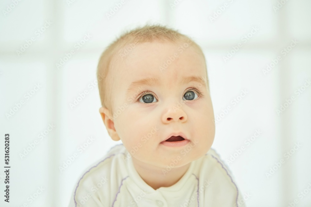 A small newborn baby is in a white room. The concept of childhood