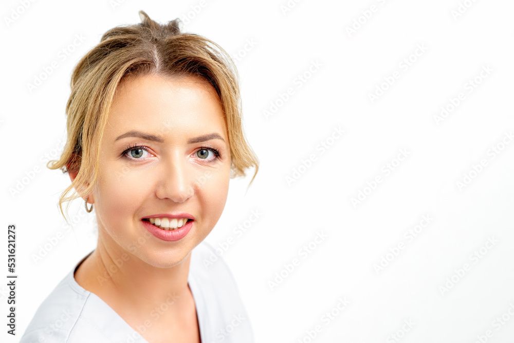 Close-up portrait of young smiling female caucasian healthcare worker standing staring at the camera on white background Close-up portrait of young smiling female caucasian healthcare worker standing staring at the camera on white background