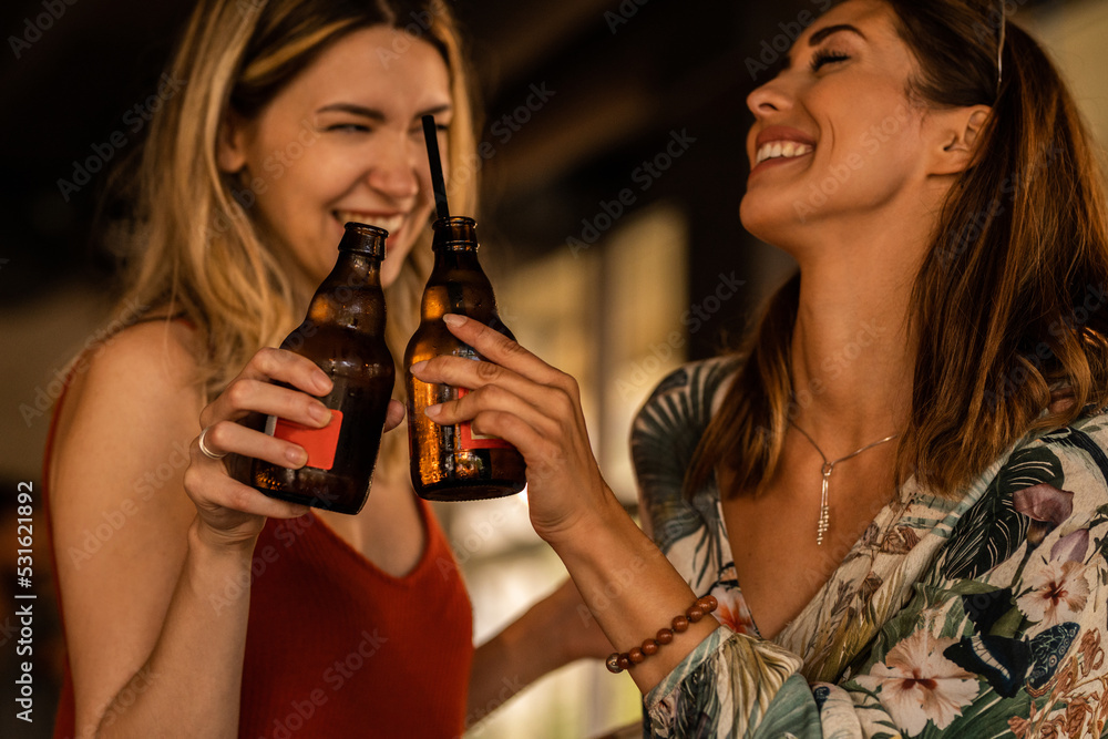 Two young women enjoying a beer together