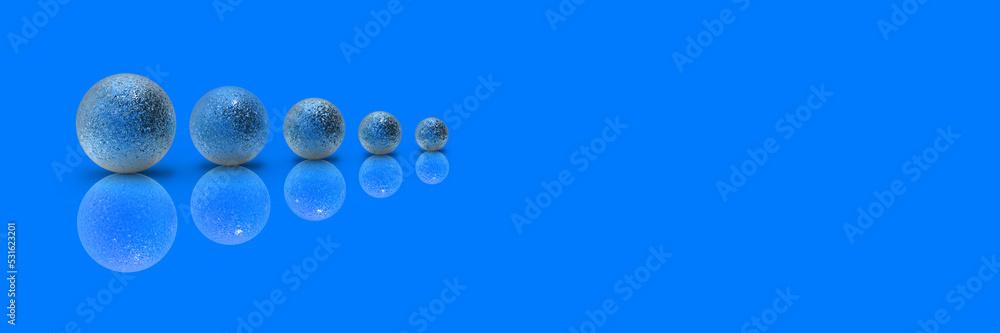 Five balls of metal of different sizes of blue color on blue background. Growth of something. Progress. Reflection. Horizontal image. Banner for insertion into site. Place for text cope space Five balls of metal of different sizes of blue color on blue background. Growth of something. Progress. Reflection. Horizontal image. Banner for insertion into site. Place for text cope space