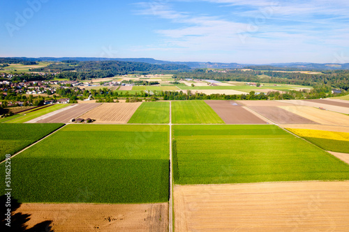 Aerial view of harvest of agricultural fields with gravel road at village of Andelfingen, Canton Zürich, on a sunny summer morning. Photo taken July 12th, 2022, Andelfingen, Switzerland. photo