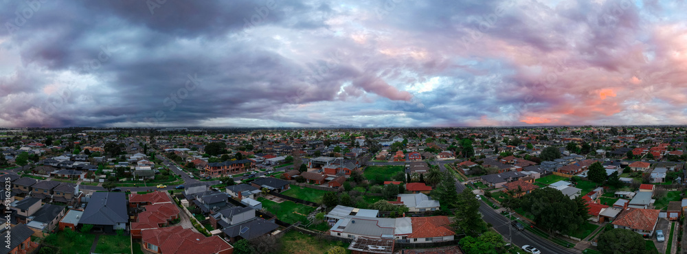 Panoramic aerial Drone view of Melbournes suburbs and CBD looking down at Houses roads and Parks Victoria Australia. Beautiful colours at Sunset