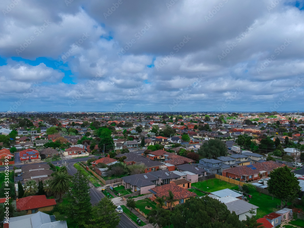 Fototapeta premium Panoramic aerial Drone view of Melbournes suburbs and CBD looking down at Houses roads and Parks Victoria Australia. Beautiful colours at Sunset