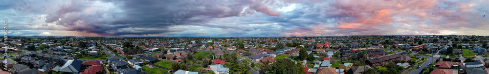 Panoramic aerial Drone view of Melbournes suburbs and CBD looking down at Houses roads and Parks Victoria Australia. Beautiful colours at Sunset