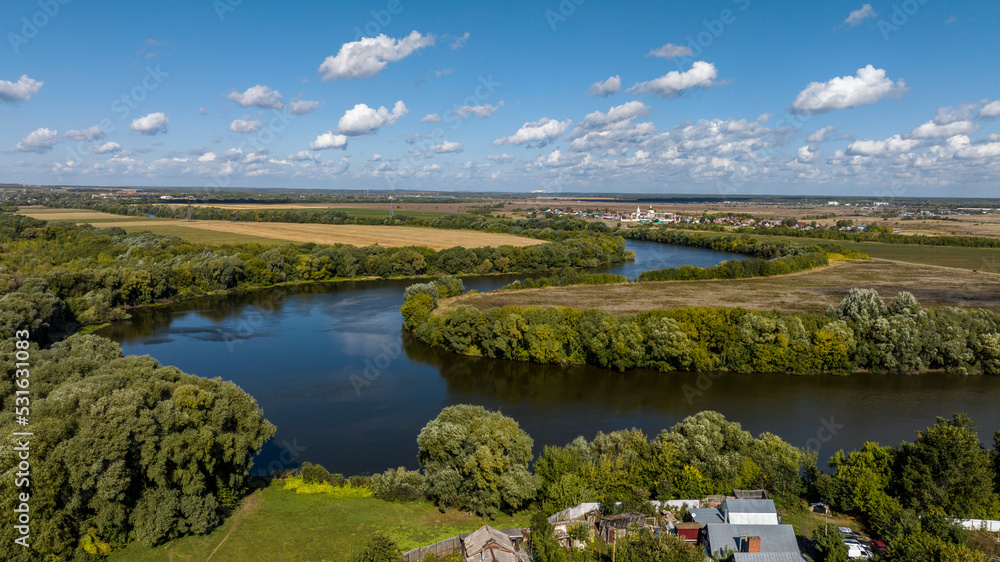 landscape with a river against a blue sky and a sunny day