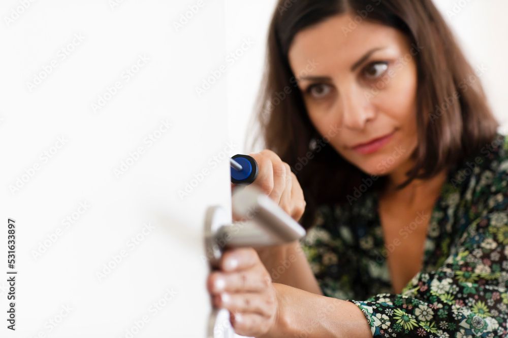 Woman fixing door Woman fixing door