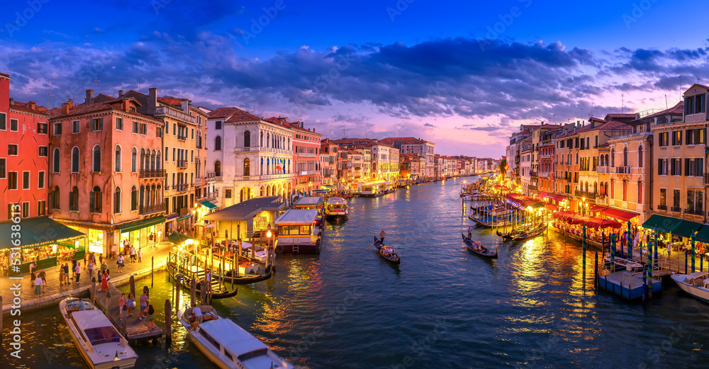 Evening panorama of the Grand Canal filled with lights in Venice, Italy. Summer holidays. Travel concept background.