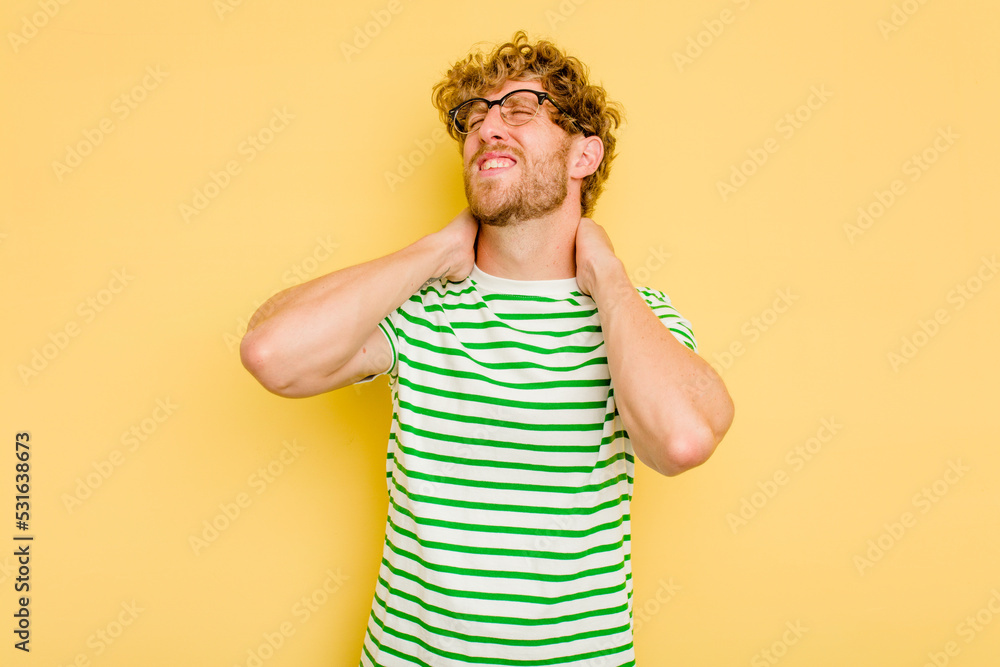 Young caucasian man isolated on yellow background suffering neck pain due to sedentary lifestyle. Young caucasian man isolated on yellow background suffering neck pain due to sedentary lifestyle.