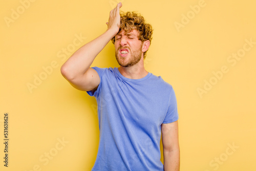 Young caucasian man isolated on yellow background forgetting something, slapping forehead with palm and closing eyes.