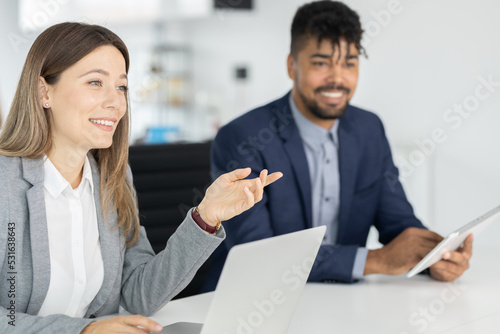 Business people on meeting, focus on business woman talking with collegue photo