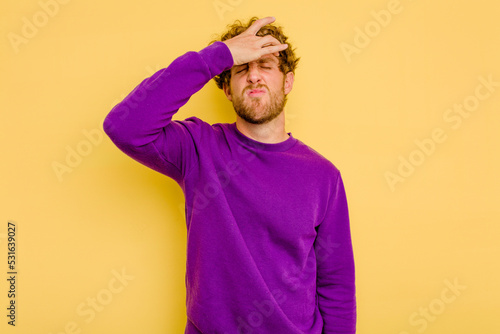 Fotografie Young caucasian man isolated on yellow background touching temples and having headache