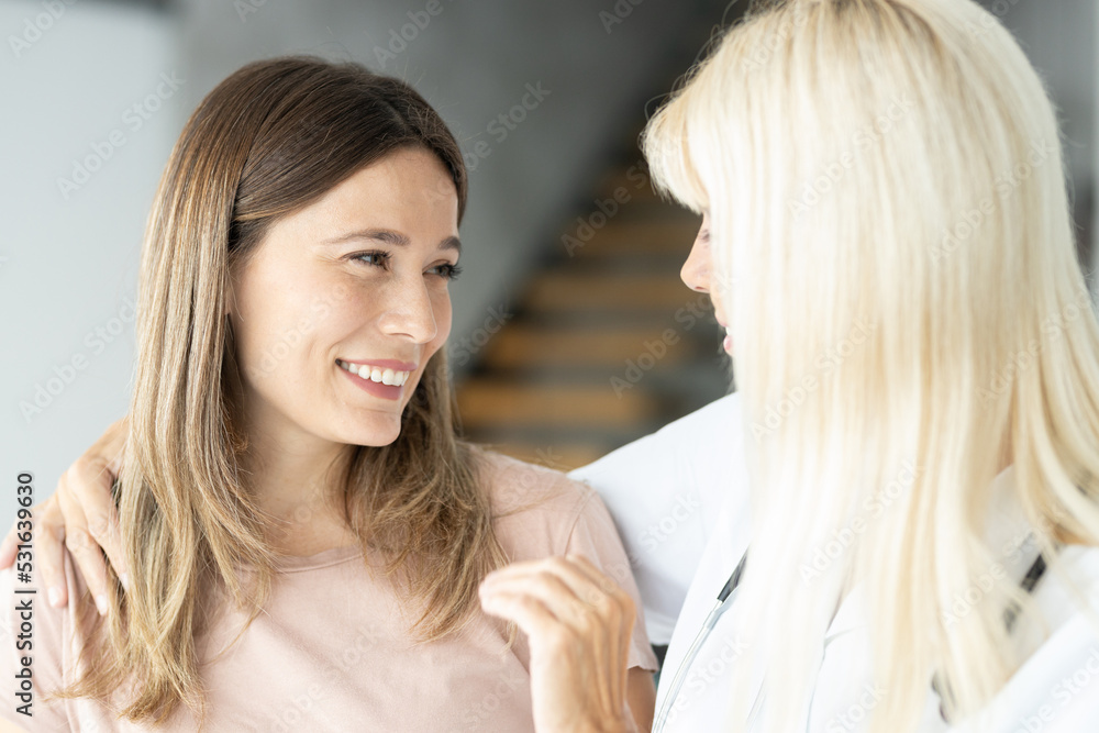 Female blonde senior doctor holding patient hands and having a positive talk Female blonde senior doctor holding patient hands and having a positive talk
