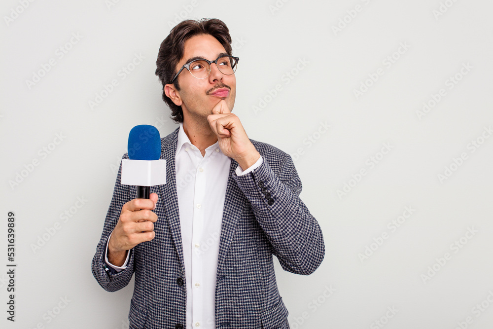 Young hispanic TV presenter man isolated on white background looking sideways with doubtful and skeptical expression. Young hispanic TV presenter man isolated on white background looking sideways with doubtful and skeptical expression.