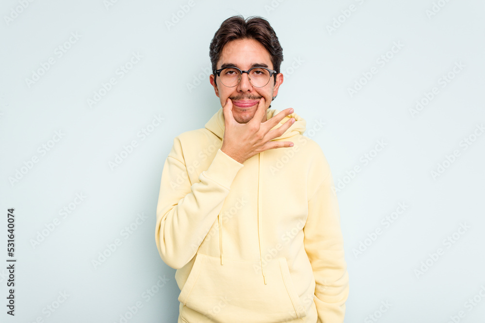 Fototapeta premium Young hispanic man isolated on blue background doubting between two options.