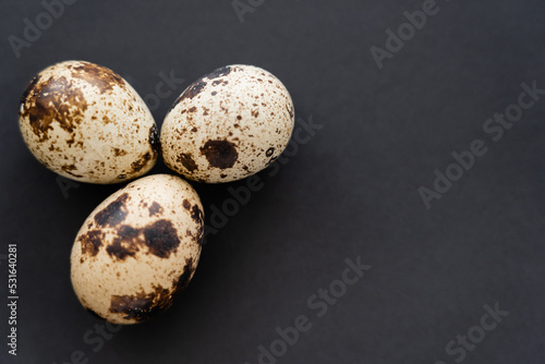 Top view of organic quail eggs on black background with copy space.