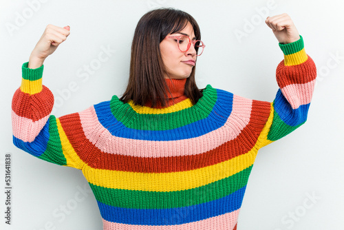 Young caucasian woman isolated on white background showing strength gesture with arms, symbol of feminine power