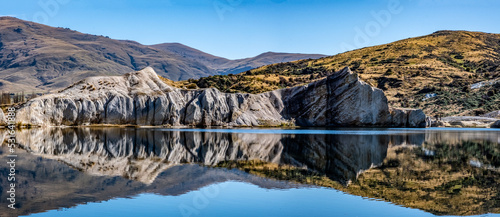 Obraz na plátně A panoramic image of the white quartz gravel cliffs reflected in the waters of t