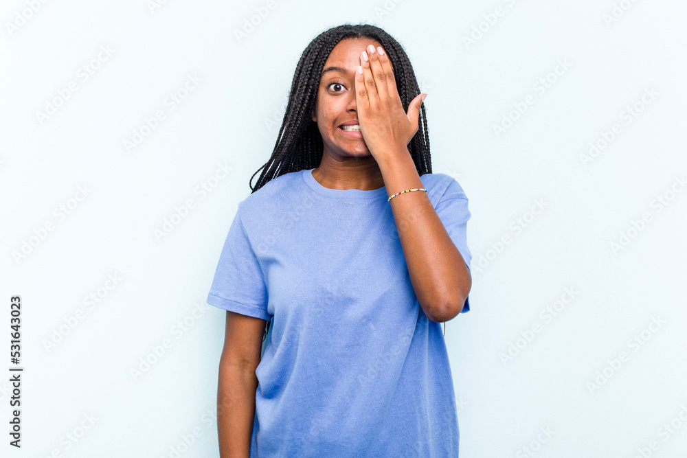 Young African American woman with braids hair isolated on blue background having fun covering half of face with palm. Young African American woman with braids hair isolated on blue background having fun covering half of face with palm.