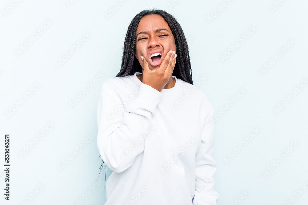 Young African American woman with braids hair isolated on blue background having a strong teeth pain, molar ache. Young African American woman with braids hair isolated on blue background having a strong teeth pain, molar ache.