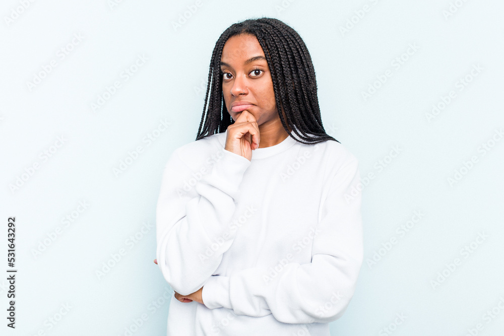 Young African American woman with braids hair isolated on blue background thinking and looking up, being reflective, contemplating, having a fantasy. Young African American woman with braids hair isolated on blue background thinking and looking up, being reflective, contemplating, having a fantasy.
