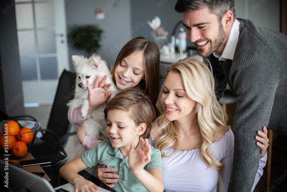 Family having their time in living room, playing with dog while having a video call Family having their time in living room, playing with dog while having a video call