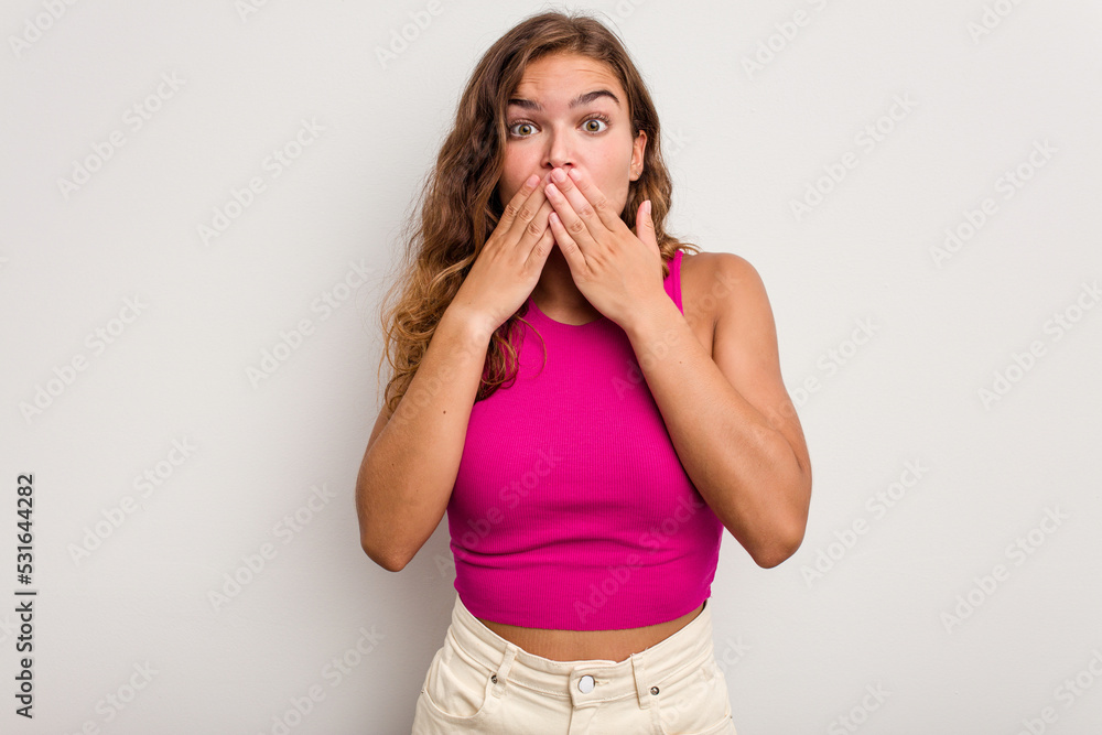 Young caucasian woman isolated on blue background shocked, covering mouth with hands, anxious to discover something new. Young caucasian woman isolated on blue background shocked, covering mouth with hands, anxious to discover something new.